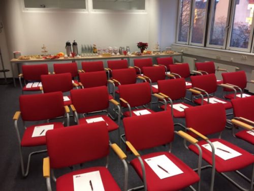 Wissensbrunch-Raum beim IFM mit Stühlen im roten Corporate Design und Unterlagen