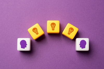 Bausteine zeigen Vermittlung von Wissen von einem Kopf zu einem anderen im Coaching