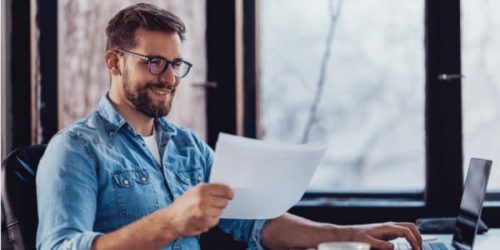 Arbeitsuchender schaut mit Freude auf seinen Bildungsgutschein