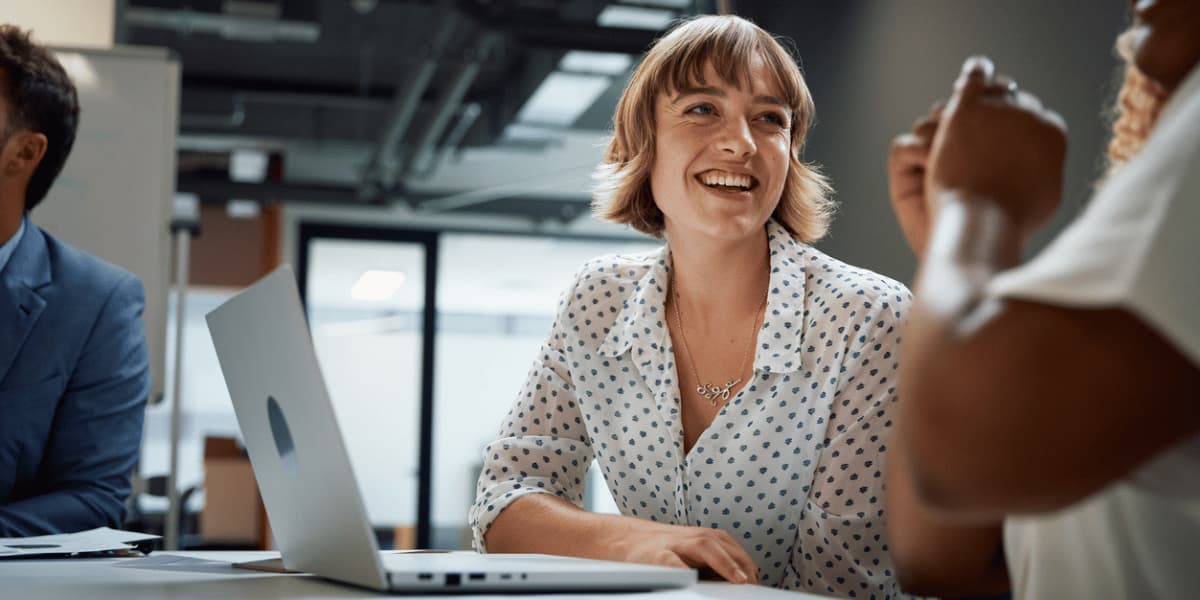 Mitarbeiterin freut sich im Gespräch über ihre neuen Weiterbildungsmöglichkeiten